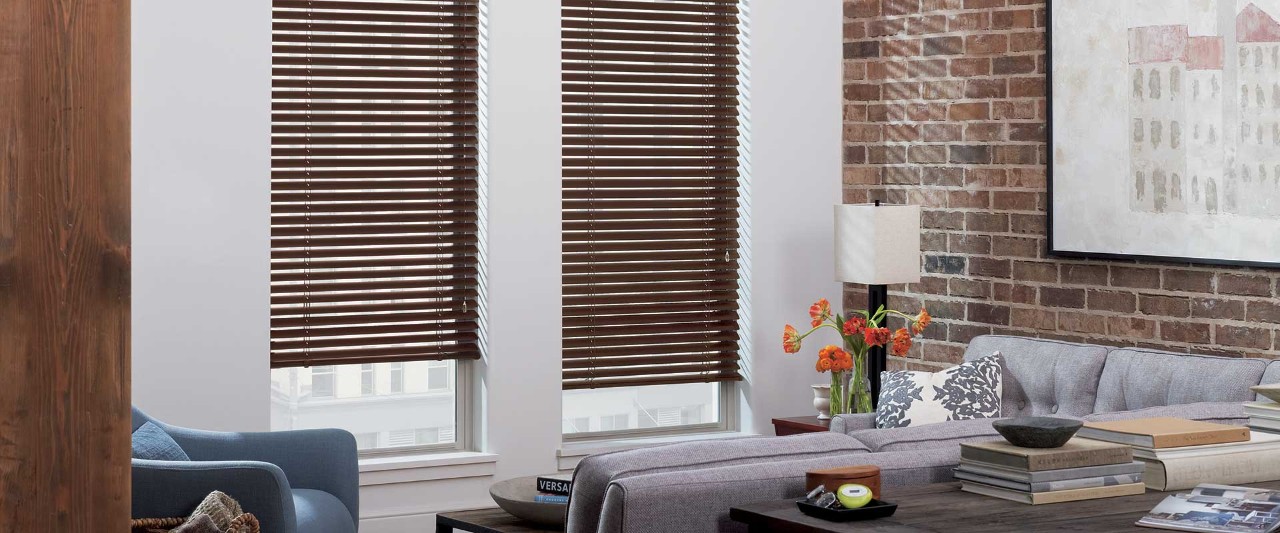 Aluminum blinds in living room with brick wall.